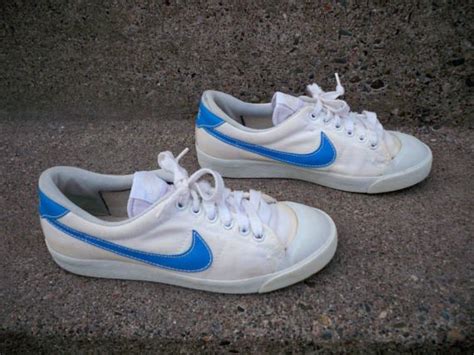 white nikes with blue swoosh.